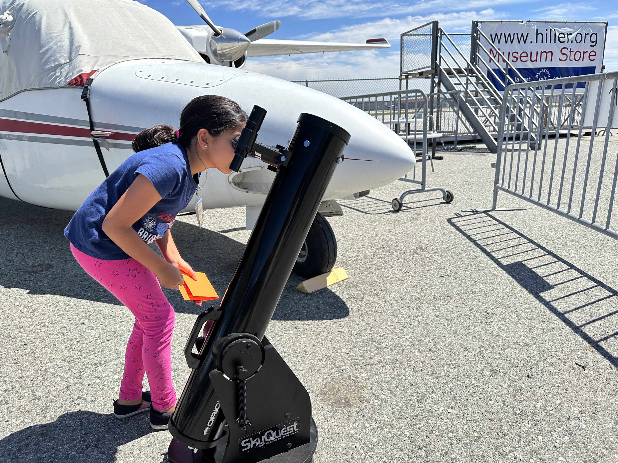 Child looking at Solar Eclipse through telescope at the Hiller Aviation Museum.